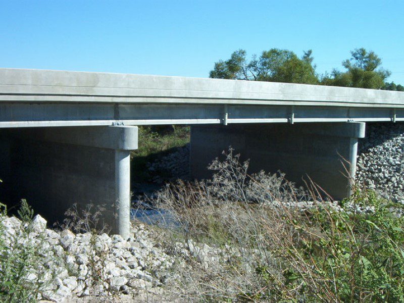 A bridge with concrete supports over the water.