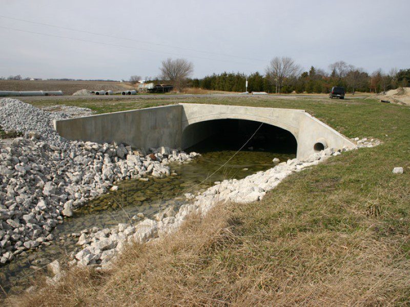 A bridge that is under water and has rocks on it.