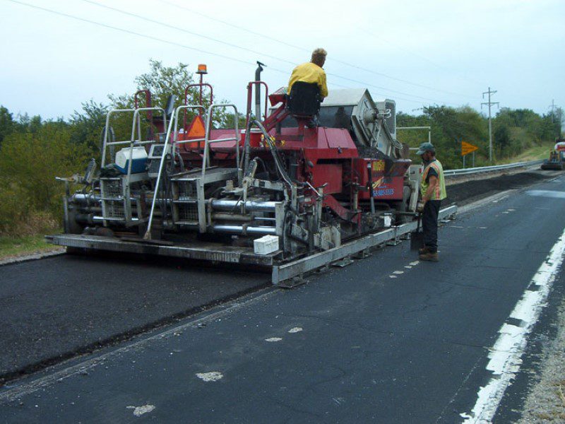 A road crew working on the side of a highway.