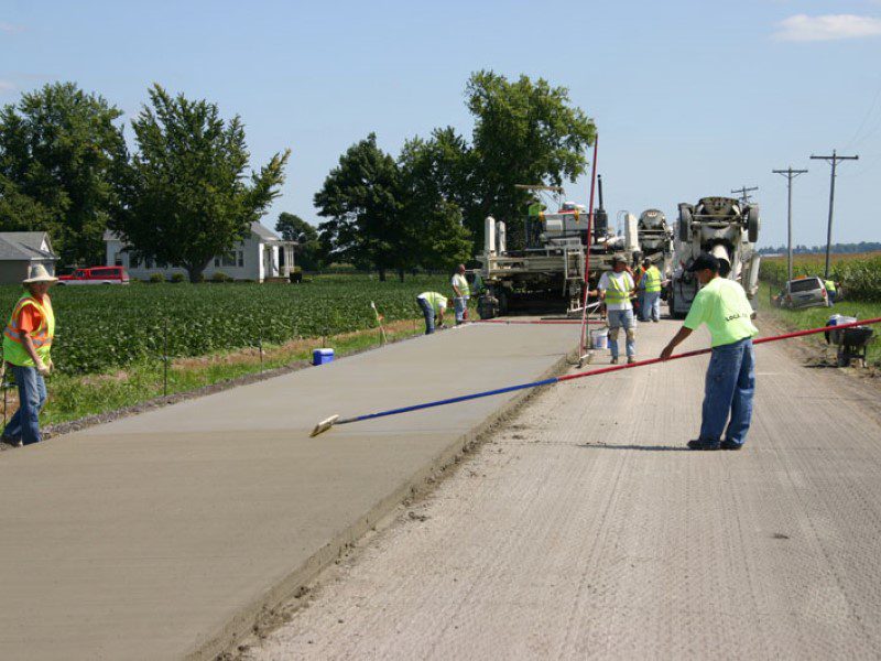 A group of men working on the side of a road.