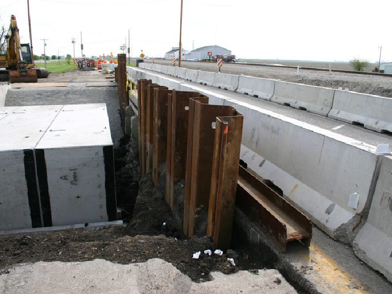 A construction site with a concrete wall and steel girders.