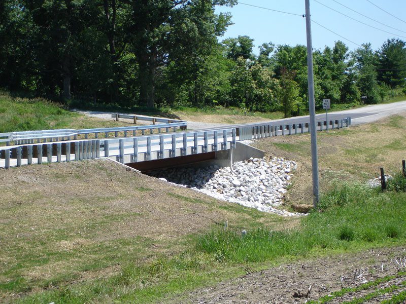 A bridge over the water is shown with rocks.