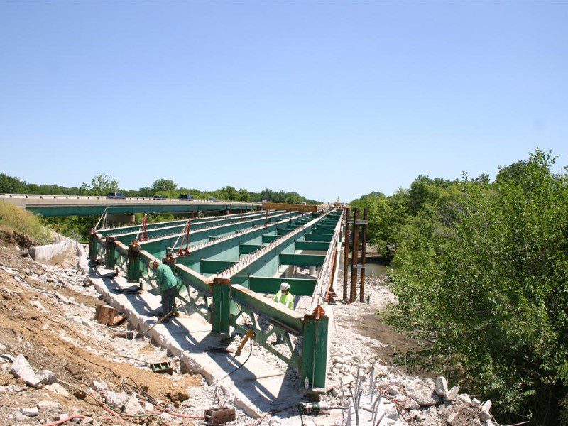 A bridge that is under construction with trees in the background.