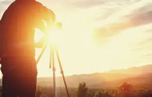 A person taking pictures of the sun setting.